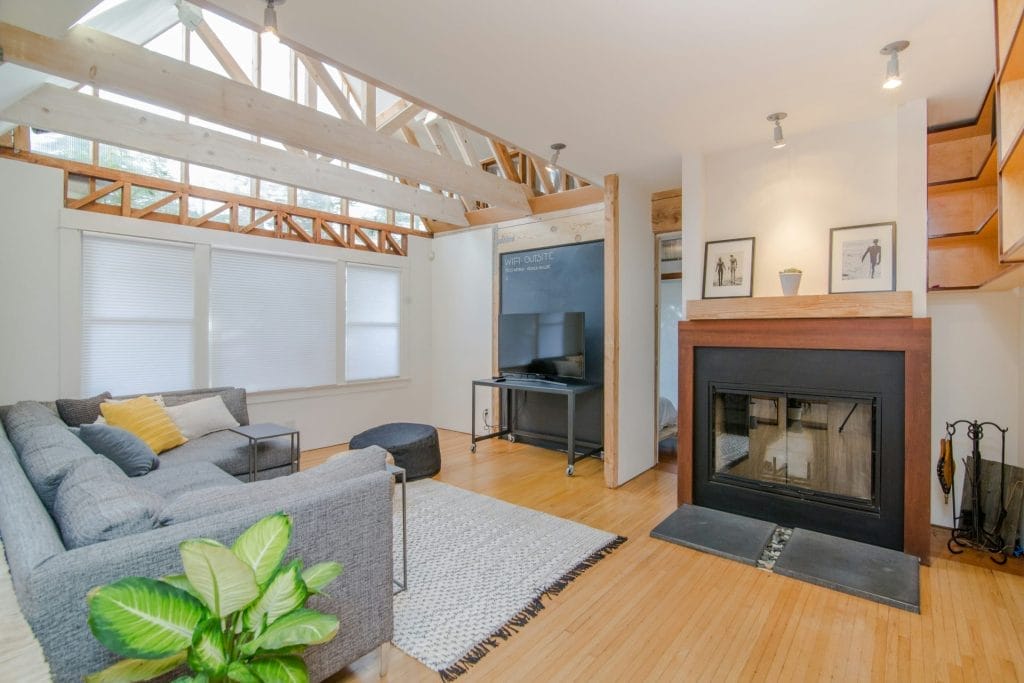 High-End Airbnb Guests:
The image shows a large and modern living room with a fireplace and a tv.