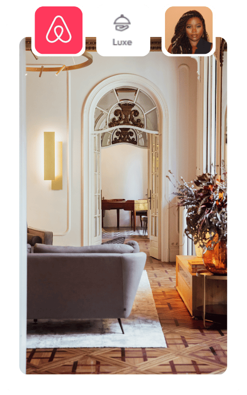 Elegant living room with a gray sofa, large arched doors, and ornate ceiling details. The wooden floor and decorative vase with flowers enhance the sophisticated ambiance for guests focused on revenue management for rental arbitrage. Icons are shown at the top.